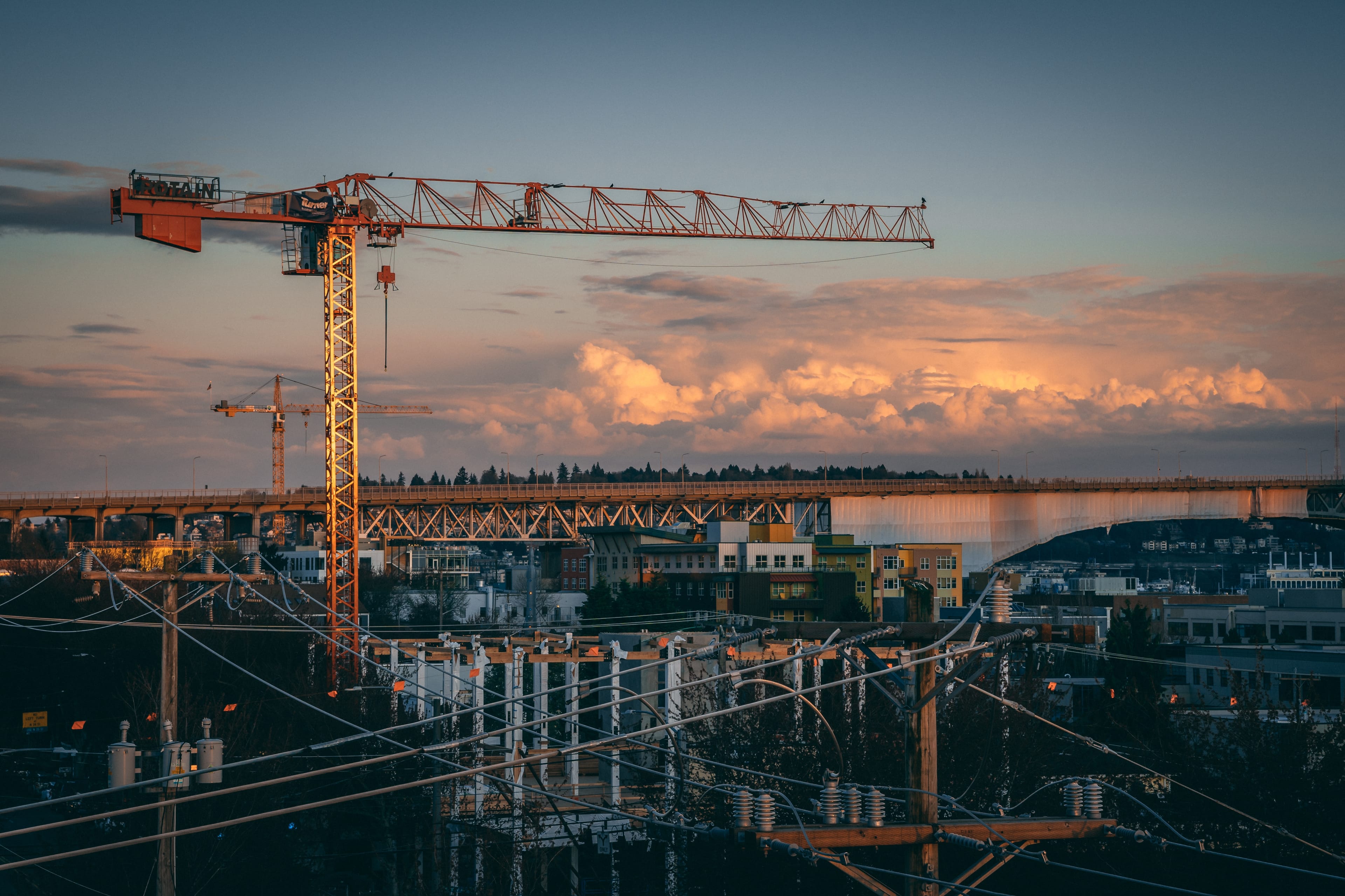 Tower crane and steel frame of a building under construction at dusk